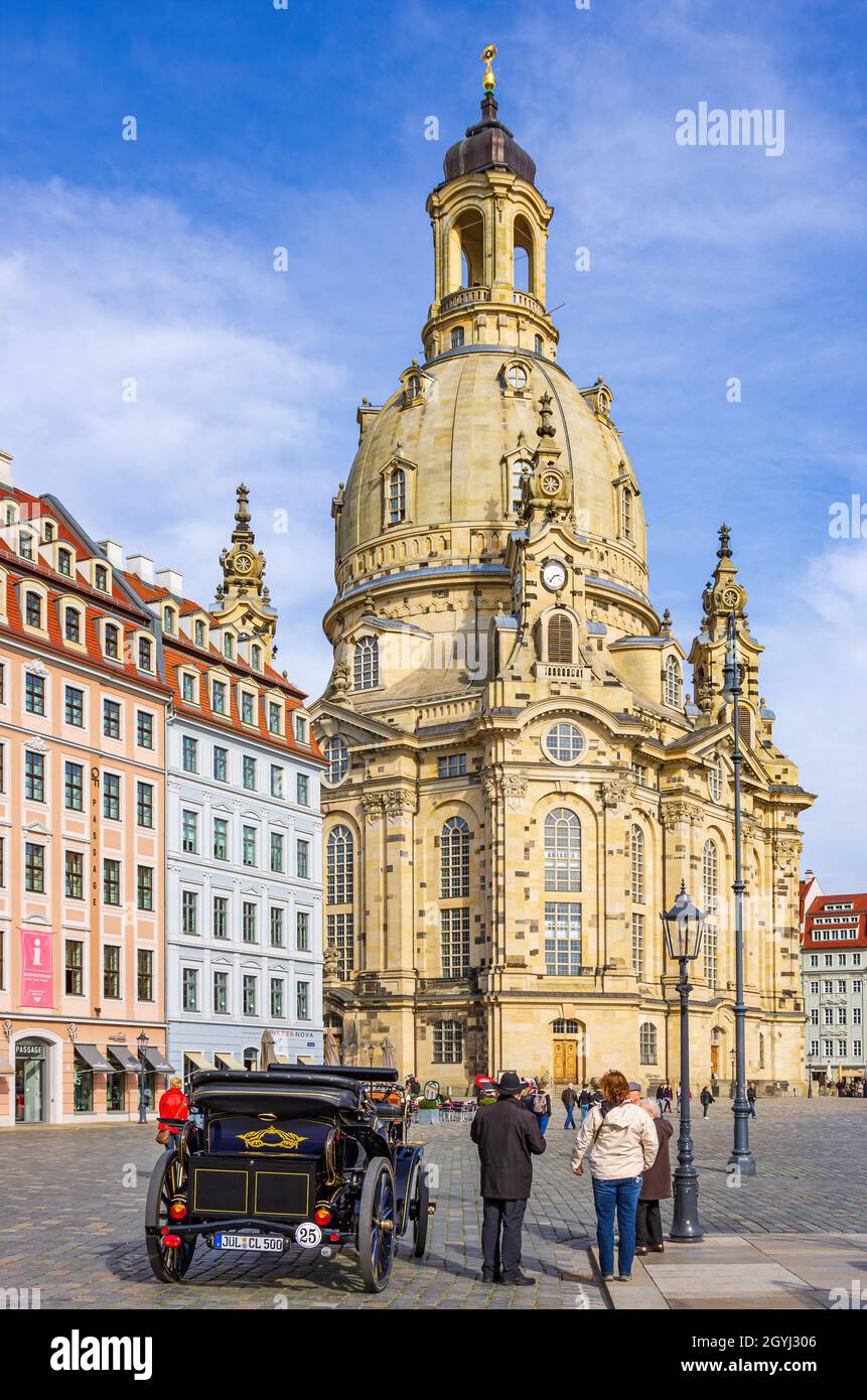 Dresden, Saxony, Germany: Tourists marvel at an electric car for city tours on Neumarkt Square in front of Frauenkirche Church. Stock Photo