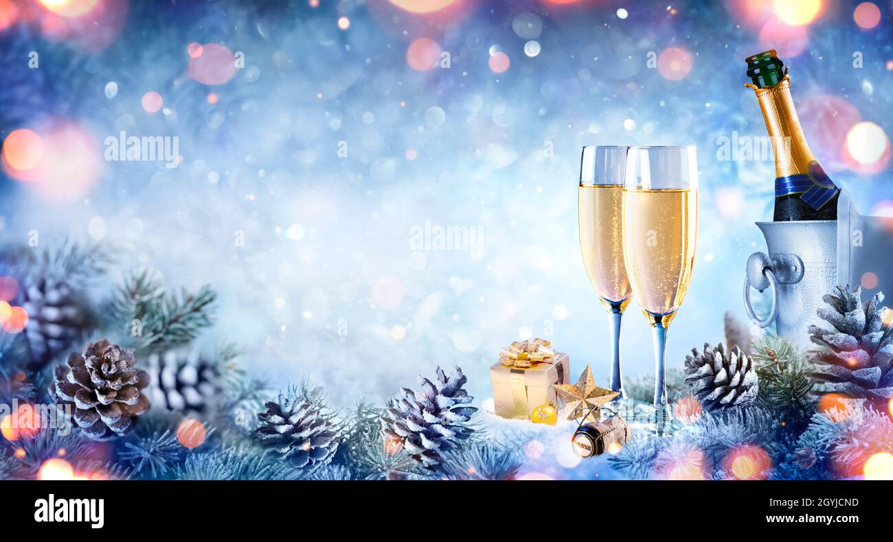 Christmas Celebration With Champagne - Flutes On Snow With Fir Branch And Bokeh Stock Photo