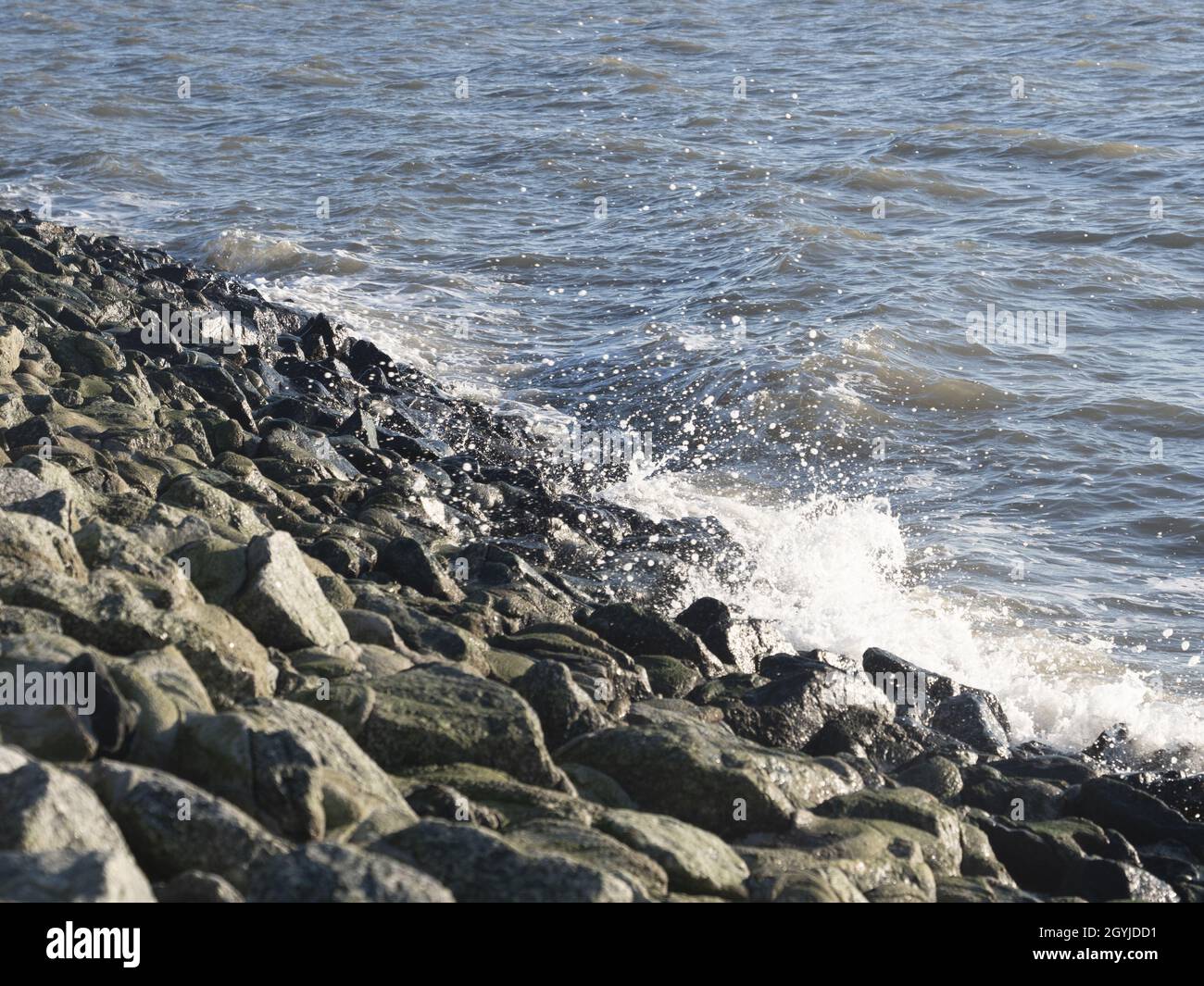 Sea waves splashing against rocks on a shore Stock Photo - Alamy
