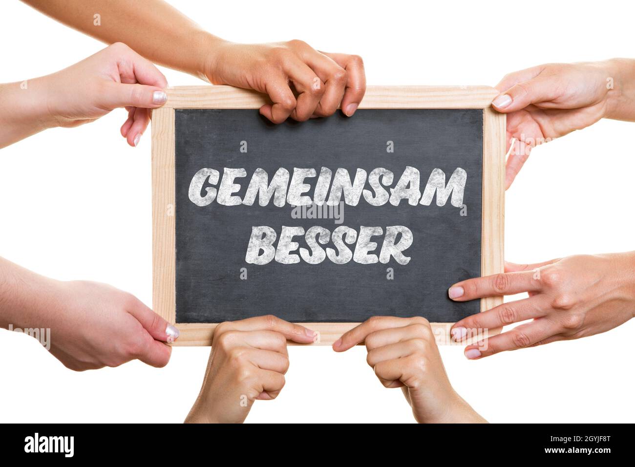 Hands hold a blackboard with the words Gemeinsam besser (German for: better together) as a team concept Stock Photo