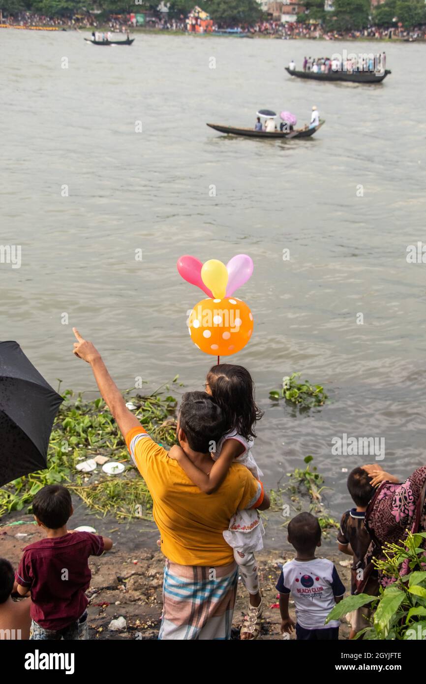 Spectator of boat race enjoying on the riverbank . This image has been captured on September-28- 2021 from Dhaka, Burigongga river, Bangladesh, South Stock Photo