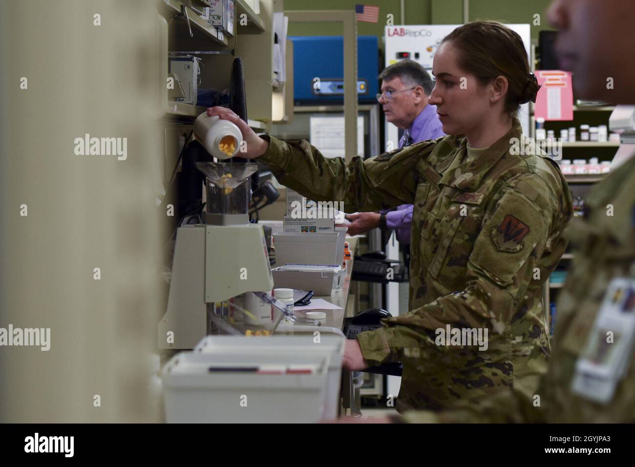 Maj. Andrea Russell, 9th Medical Support Squadron pharmacy element chief, pours pills into a