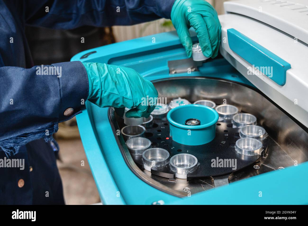 The laboratory technician sets the cups with samples into spectrometer
