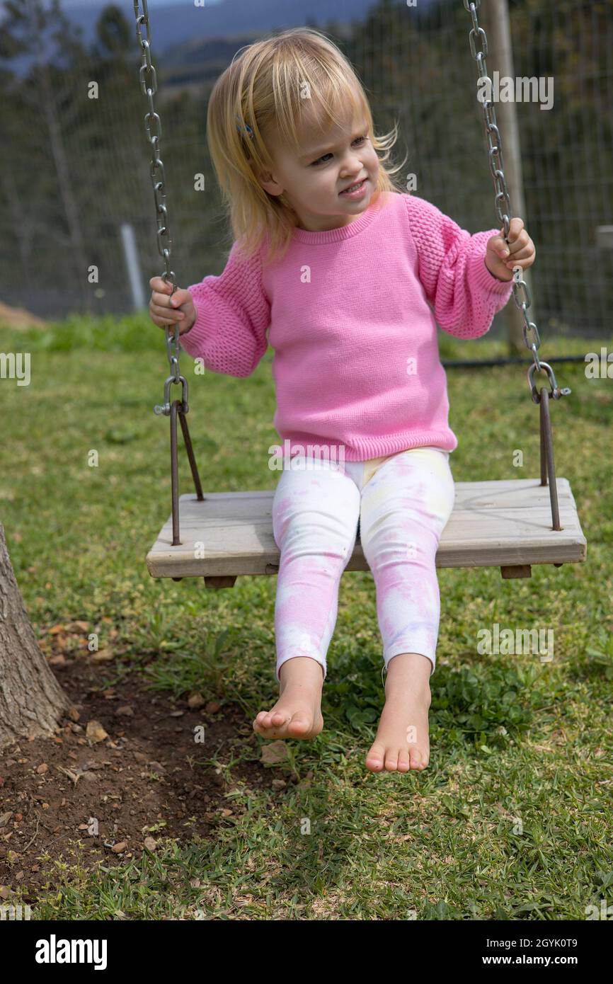 Young blond girl on a swing Stock Photo