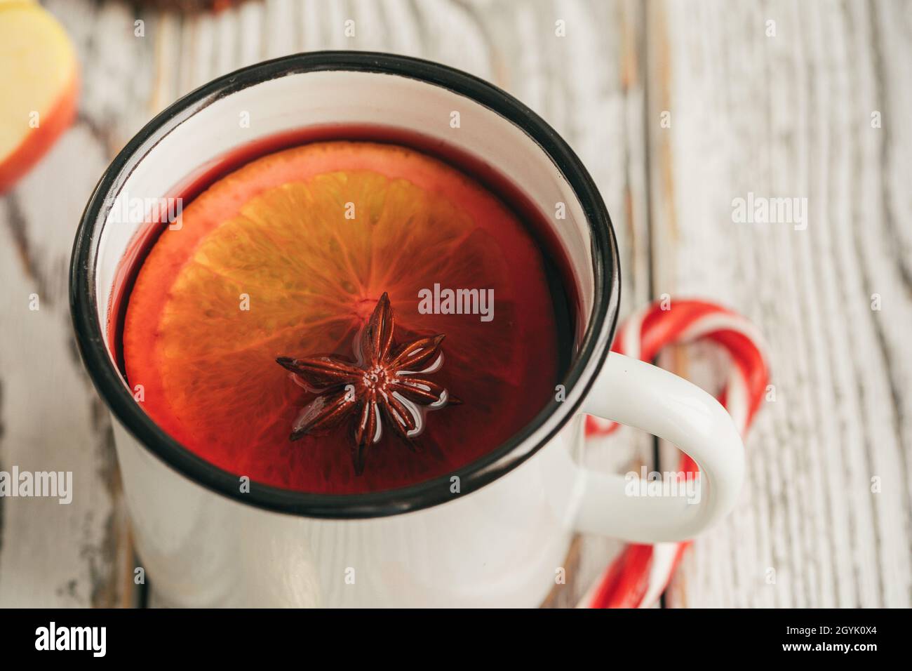 Mulled wine in a white cup with candy cane close up Stock Photo