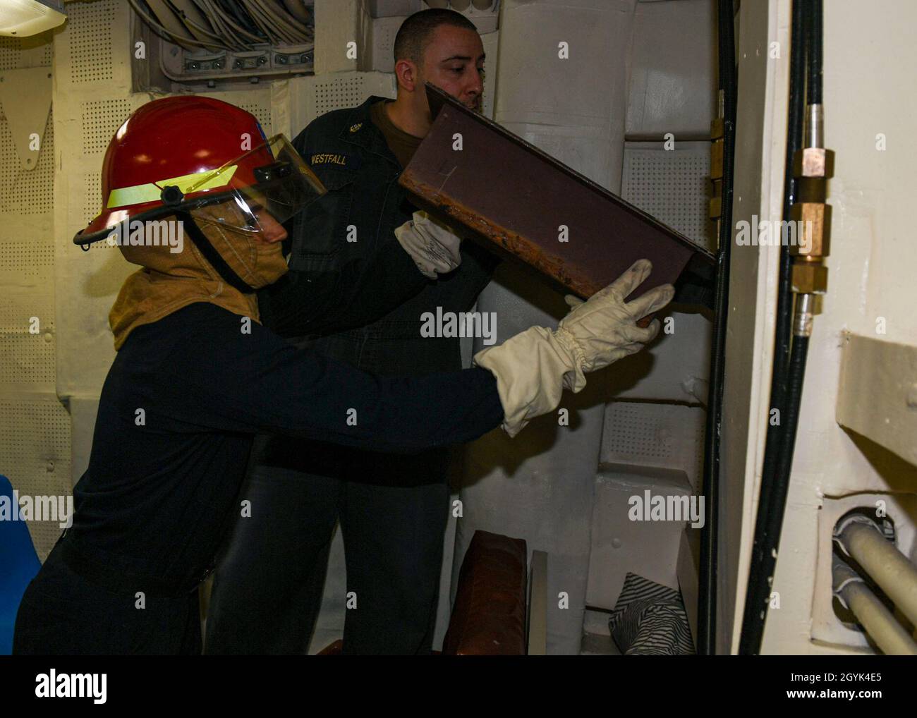 200113-N-PC620-0026 ARABIAN SEA (Jan. 13, 2020) Damage Control Fireman Alexis Rodriguez-Rivera places a box patch over simulated bulkhead damage during an at-sea fire party drill aboard the guided-missile cruiser USS Normandy (CG 60). The Normandy is part of the Harry S. Truman Carrier Strike Group and is deployed to the U.S. 5th Fleet area of operations in support of naval operations to ensure maritime stability and security in the Central Region, connecting the Mediterranean and Pacific through the western Indian Ocean and three strategic choke points. (U.S. Navy photo by Mass Communication Stock Photo