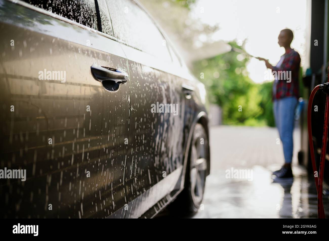 Woman washes off foam from the car, hand auto wash Stock Photo Alamy