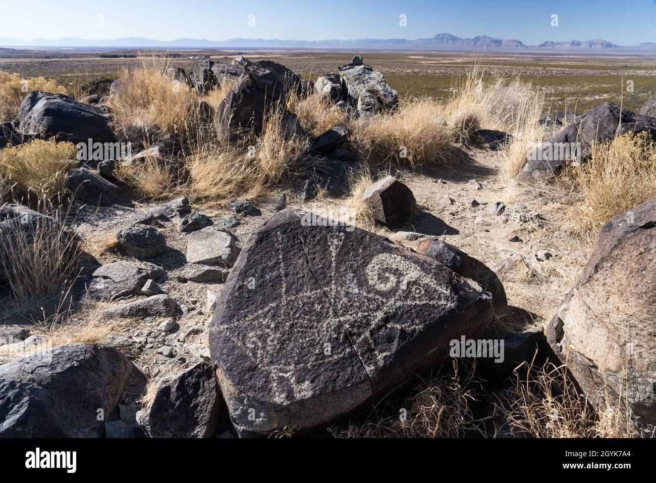 A bighorn sheep pierced by arrows carved on a basalt boulder in the Three Rivers Petroglyph Site, New Mexico. Stock Photo
