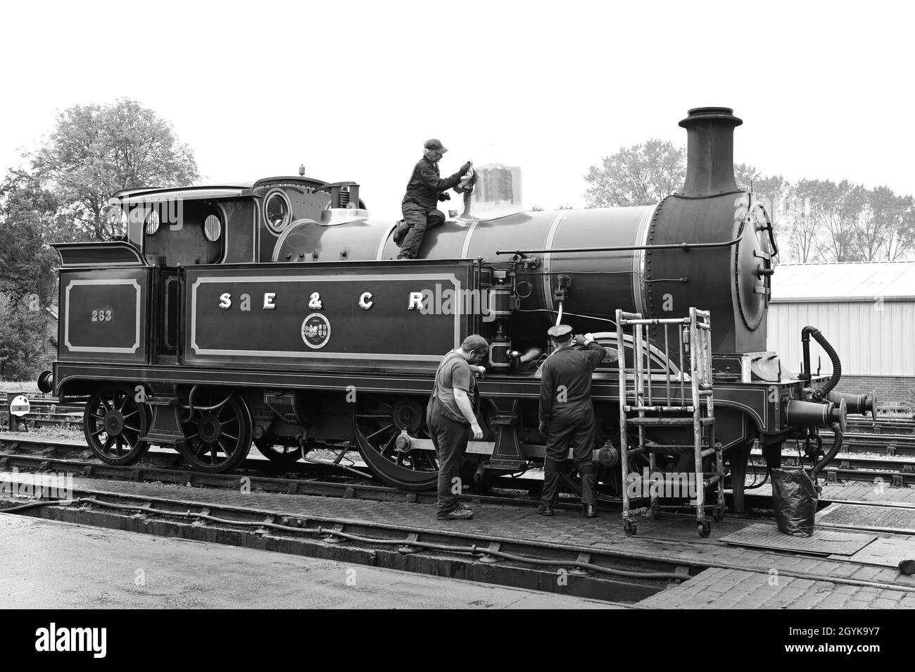 Sheffield Park, East Sussex, UK-October 08 2021: Maintenance staff cleaning a steam locomotive at Sheffield Park. Stock Photo