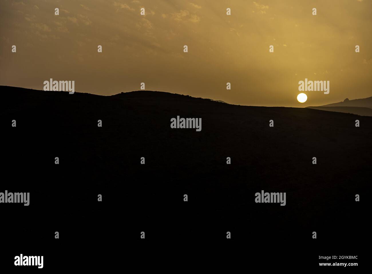 Golden sun over the silhouettes of the mountains Stock Photo - Alamy