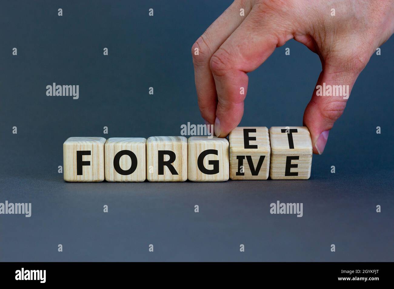 Forgive and forget symbol. Businessman turns wooden cubes and changes the word 'forgive' to 'forget'. Beautiful grey background, copy space. Business, Stock Photo