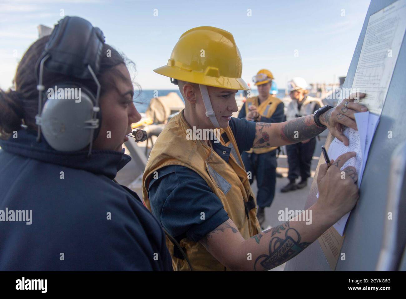 PACIFIC OCEAN (Jan. 18, 2020) Boatswain’s Mate 3rd Class Fawn Savoie, from Houma, La., right, reviews a line-handling muster sheet while Seaman Samantha Sorbellini, from Poughquag, N.Y., reports mustering information to the pilot house aboard the Arleigh Burke-class guided-missile destroyer USS Paul Hamilton (DDG 60) Jan. 18, 2020. Paul Hamilton, part of the Theodore Roosevelt Carrier Strike Group, is on a scheduled deployment to the Indo-Pacific. (U.S. Navy photo by Mass Communication Specialist 3rd Class Matthew F. Jackson) Stock Photo