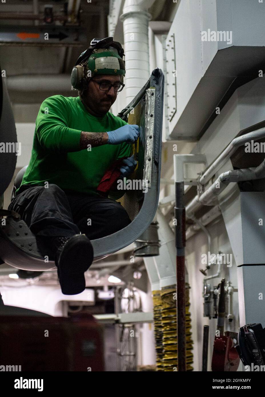 PACIFIC OCEAN (Jan. 21, 2020) Aviation Machinist’s Mate 2nd Class Jacob Burkindine, from Fresno, Calif., removes corrosion from the engine bay cowling on an MH-60R Sea Hawk, assigned to the “Scorpions” of Helicopter Maritime Strike Squadron (HSM) 49, in the hangar bay aboard the Arleigh Burke-class guided-missile destroyer USS Rafael Peralta (DDG 115) Jan. 21, 2020. Rafael Peralta, part of the Theodore Roosevelt Carrier Strike Group, is on a scheduled deployment to the Indo-Pacific. (U.S. Navy photo by Mass Communication Specialist 2nd Class Jason Isaacs) Stock Photo