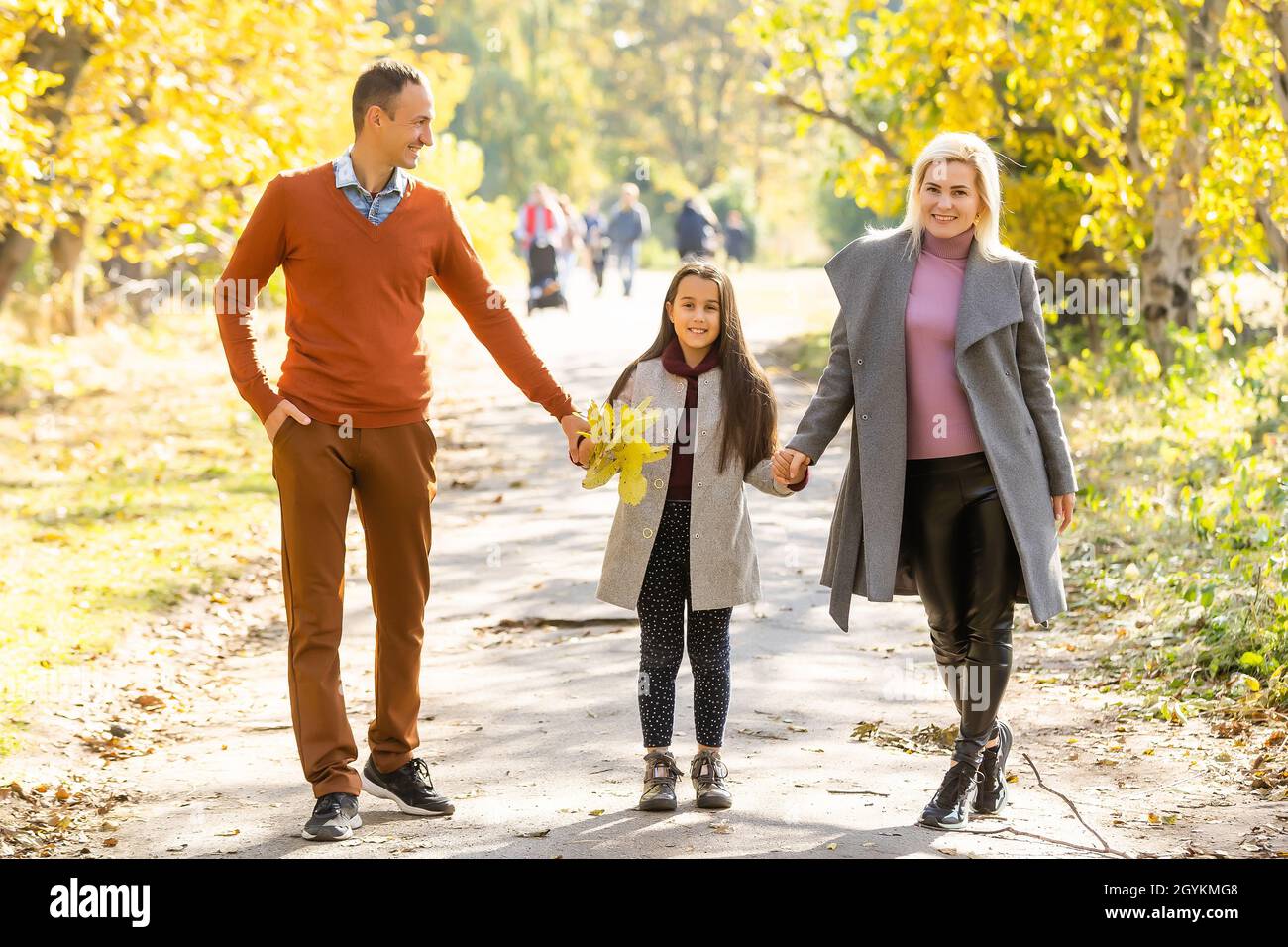Young happy family while walking in the autumn park Stock Photo - Alamy