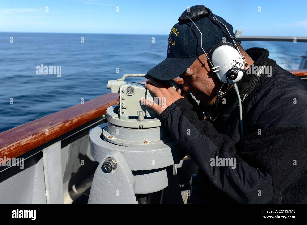 PACIFIC OCEAN (Jan. 21, 2020) Seaman Aaron Bactad, from San Francisco, looks through a telescopic alidade on the bridge wing of the Arleigh Burke-class guided-missile destroyer USS Russell (DDG 59) Jan. 21, 2020. Russell, part of the Theodore Roosevelt Carrier Strike Group, is on a scheduled deployment to the Indo-Pacific. (U.S. Navy photo by Mass Communication Specialist 3rd Class Sean Lynch) Stock Photo