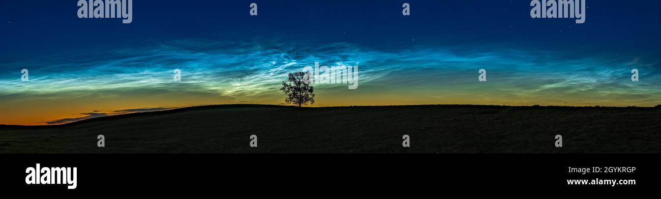 A 45° panorama of the massive 'grand display' of noctilucent clouds at dusk on June 16, 2021 from 'One Tree Hill' near home in southern Alberta. This Stock Photo