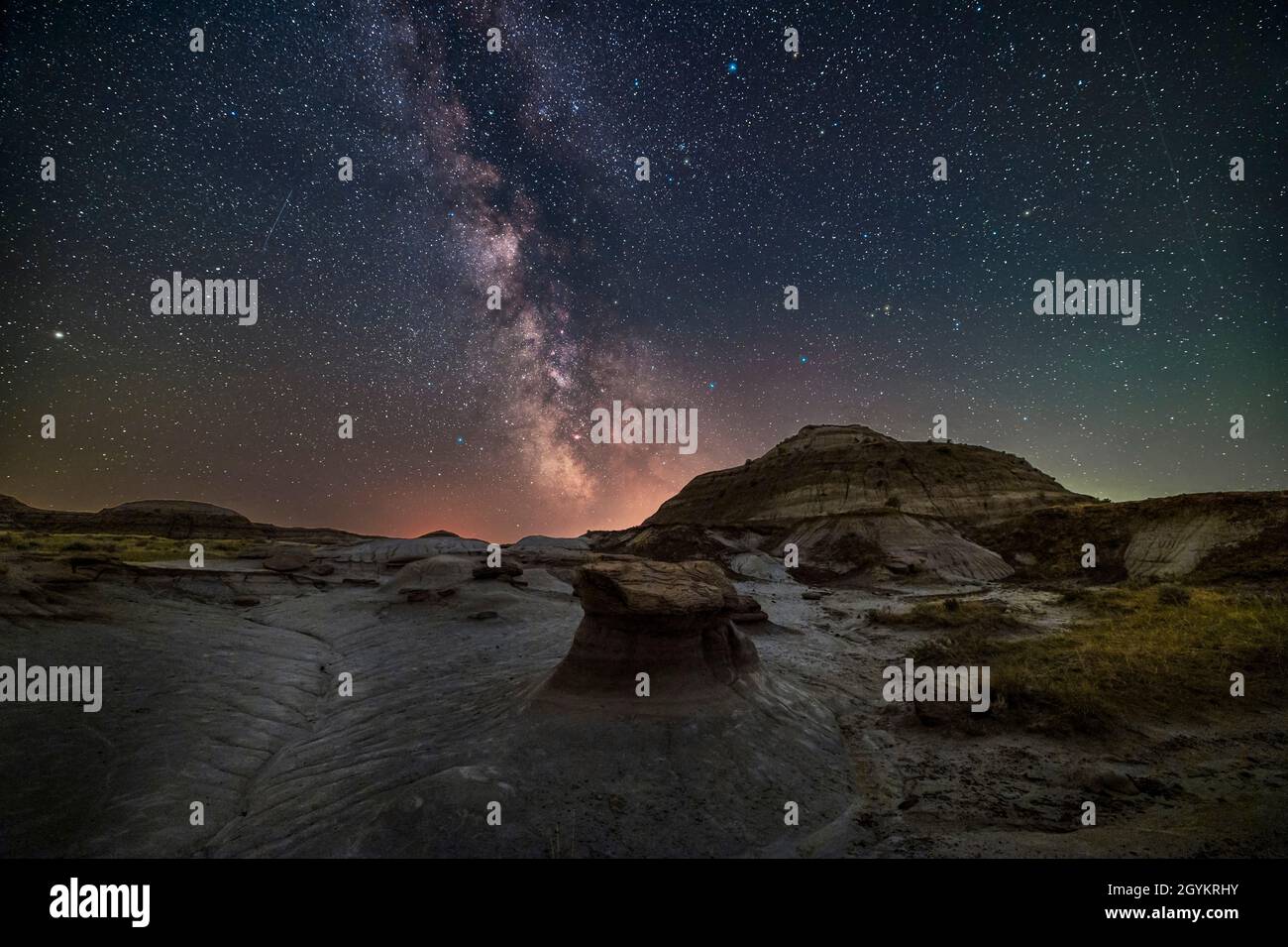 The summer Milky Way and galactic core region over the formations at Dinosaur Provincial Park, Alberta, July 9, 2021, on a warm moonless night.  This Stock Photo