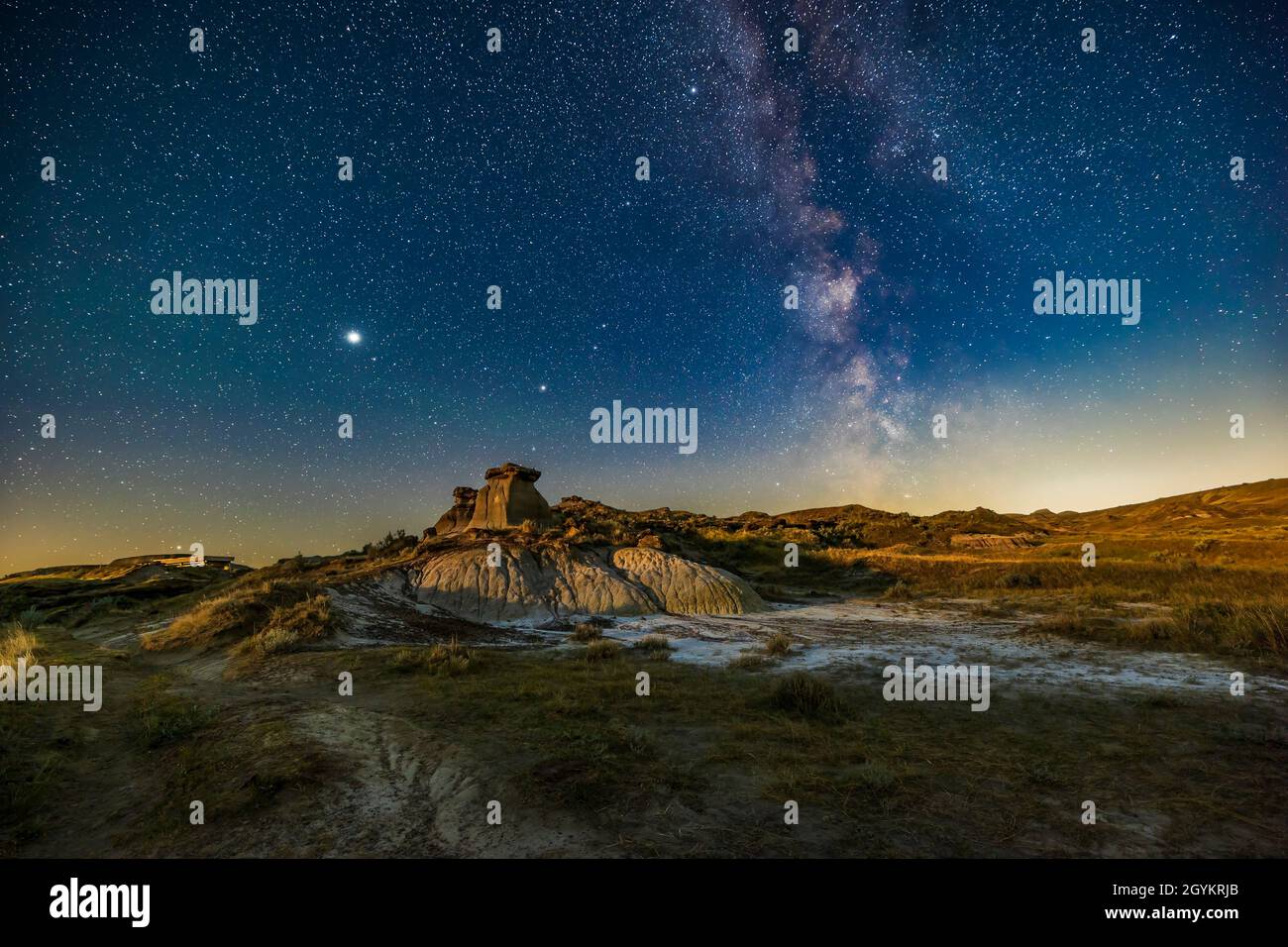 The summer Milky Way in the southwest with the planets Jupiter (brightest) and Saturn (centre) to the east, over the Badlands formations at the Trail Stock Photo