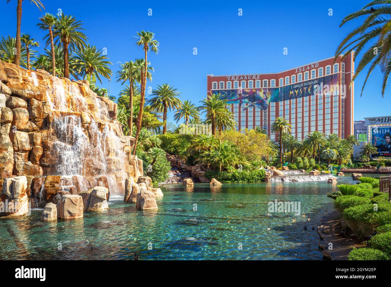 Las Vegas, NV, USA – June 8, 2021: Waterfall at The Mirage Hotel and Casino with Treasure Island in the background located in Las Vegas, Nevada. Stock Photo