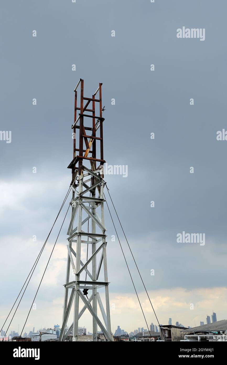 abandon or deprecated of Wireless Communication Antenna pole, Mobile phone mast antenna pole on top of dilapidated building Stock Photo
