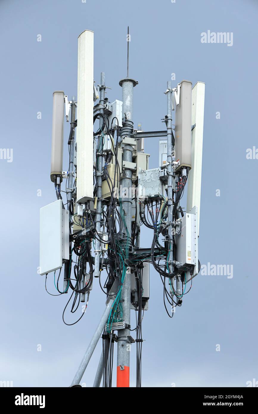 Close up equipment section of Wireless Communication Antenna pole, Mobile phone mast antenna pole on top of dilapidated building Stock Photo