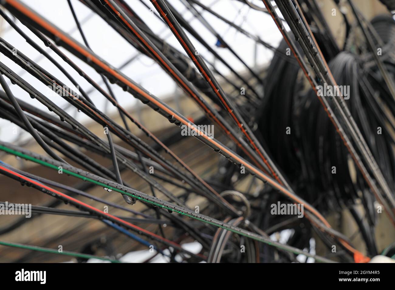 disorderly  Electric and signal wires on a post in city, messy of electrical wires and internet fiber signal line on electric poles. Stock Photo