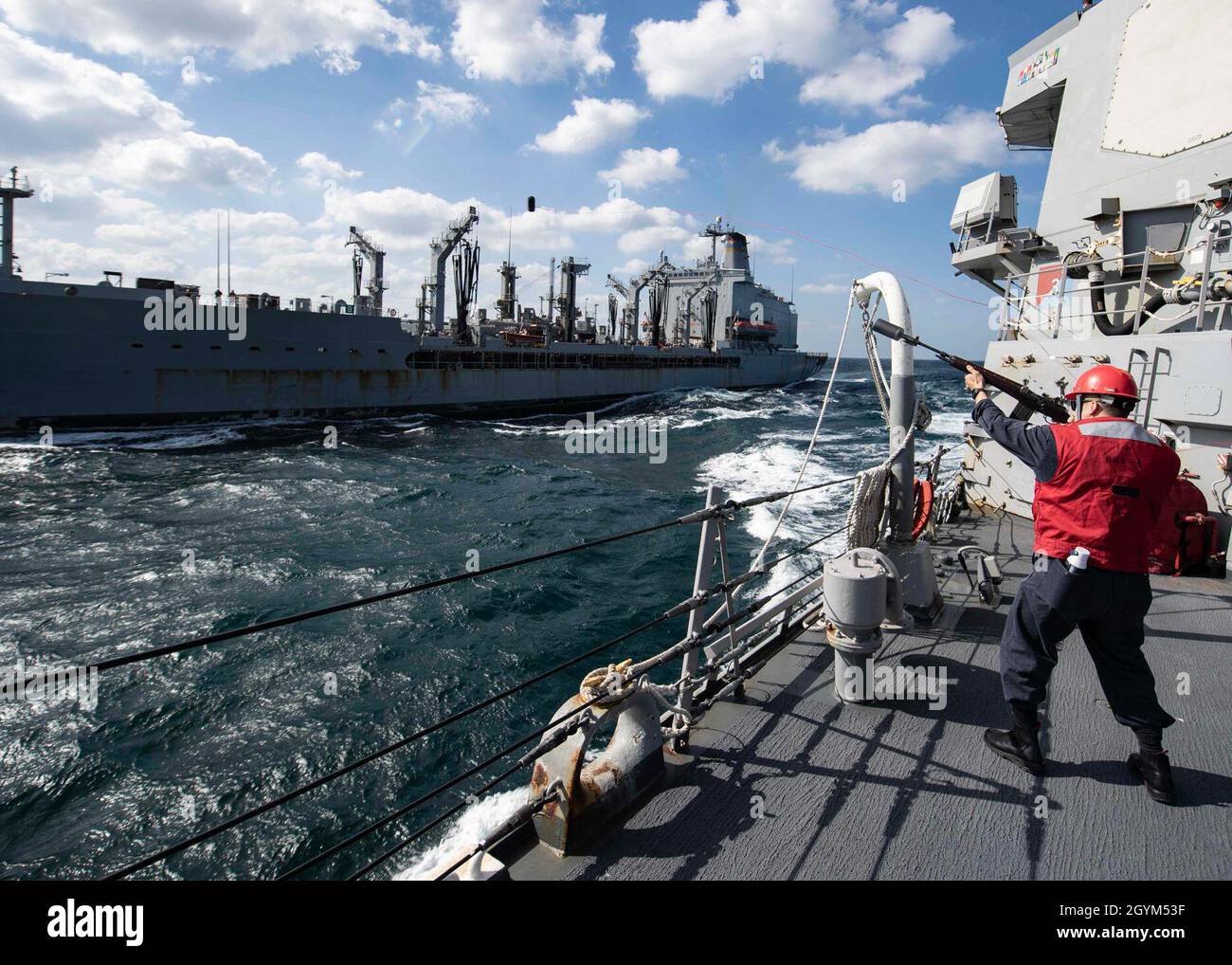 ARABIAN GULF (Jan. 27, 2020) - Fire Controlman 2nd Class Brandon Nguyen, fires a shot line to the fleet replenishment oiler USNS Walter S. Diehl (T-AO-193) during a replenishment-at-sea evolution aboard the guided-missile destroyer USS Carney (DDG 64), Jan. 27, 2020. Carney is deployed to the U.S. 5th Fleet area of operations in support of naval operations to ensure maritime stability and security in the Central Region, connecting the Mediterranean and Pacific through the Western Indian Ocean and three strategic choke points. (U.S. Navy photo by Mass Communication Specialist 1st Class Fred Gra Stock Photo