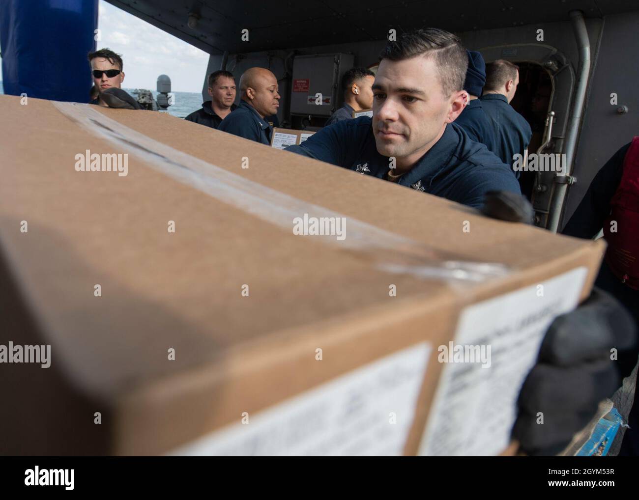 ARABIAN GULF (Jan. 27, 2020) - Logistics Specialist 1st Class Bradley Rash removes a box from a pallet to pass along to the working party aboard the guided-missile destroyer USS Carney (DDG 64) during a replenishment-at-sea with the fleet replenishment oiler USNS Walter S. Diehl (T-AO-193), Jan. 27, 2020. Carney is deployed to the U.S. 5th Fleet area of operations in support of naval operations to ensure maritime stability and security in the Central Region, connecting the Mediterranean and Pacific through the Western Indian Ocean and three strategic choke points. (U.S. Navy photo by Mass Comm Stock Photo