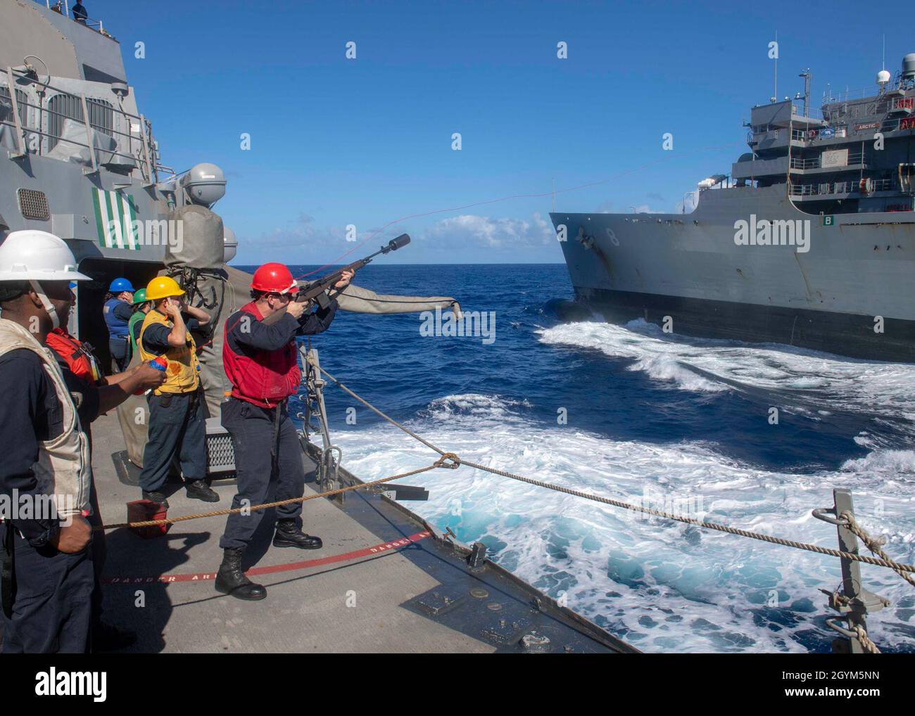 PACIFIC OCEAN (Jan. 27, 2020) Gunner’s Mate 3rd Class Joshua Davis, from Pensacola, Fla., fires a shot line from aboard the Arleigh Burke-class guided-missile destroyer USS Paul Hamilton (DDG 60) to the Military Sealift Command fast combat support ship USNS Arctic (T-AO 8) during a replenishment-at-sea Jan. 27, 2020. Paul Hamilton, part of the Theodore Roosevelt Carrier Strike Group, is on a scheduled deployment to the Indo-Pacific. (U.S. Navy photo by Mass Communication Specialist 3rd Class Matthew F. Jackson) Stock Photo