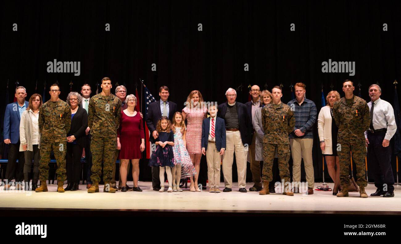 Staff Sgt. Leary Reicharwarfel (left), Sgt. Anders Larson, Cpl. Austin McMullen, and Cpl. Timothy Watson pose for a photo with their families after receiving the Navy and Marine Corps Medal aboard Marine Corps Air Station Cherry Point, North Carolina, January 28, 2019. The Marines received this award for his heroic efforts while saving a family at Atlantic Beach, North Carolina. (U.S. Marine Corps photo by Staff Sgt. William L. Holdaway) Stock Photo