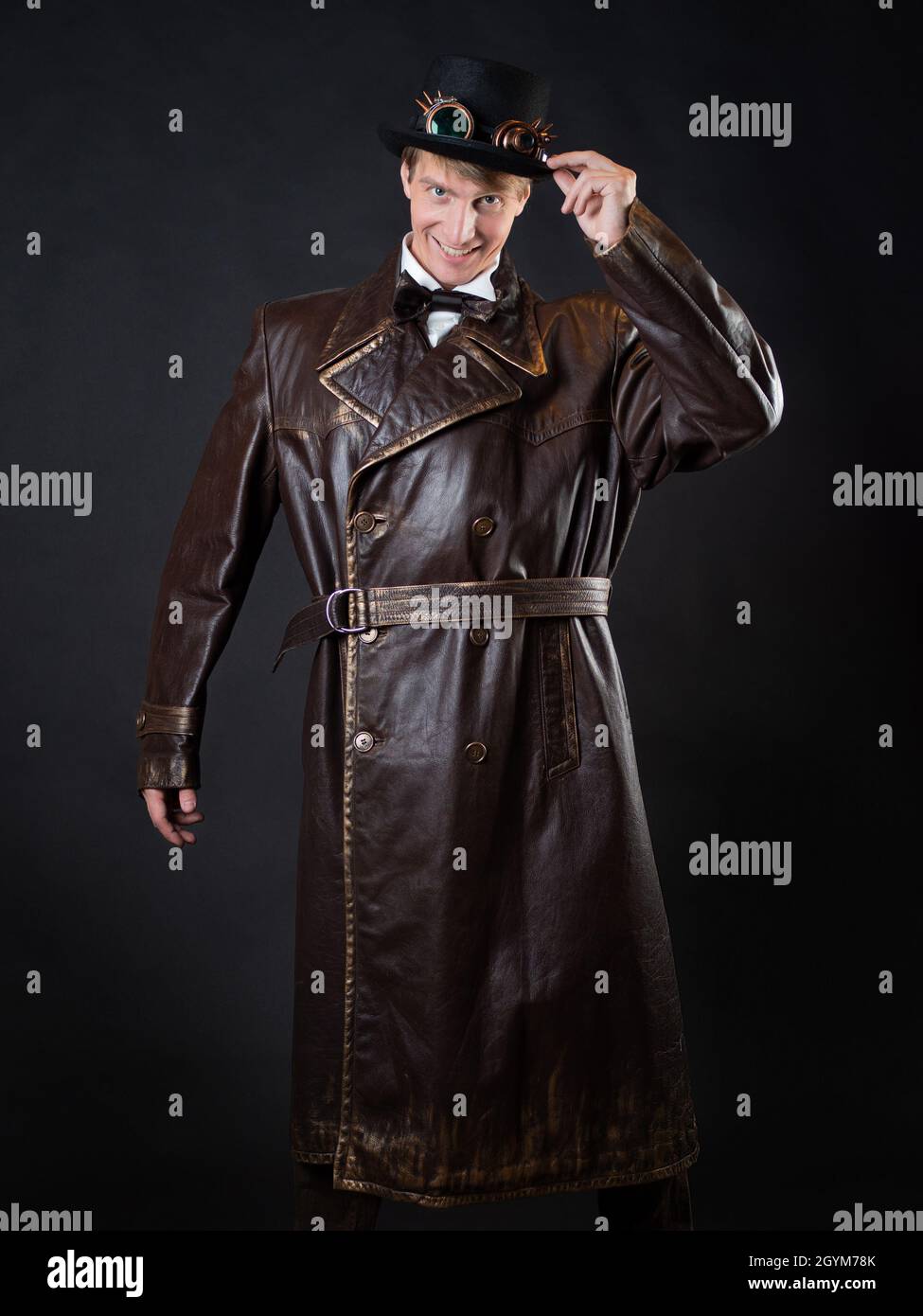 Funny man in a ridiculous leather coat and a top hat, vintage style of  clothing, photo on a black background Stock Photo - Alamy