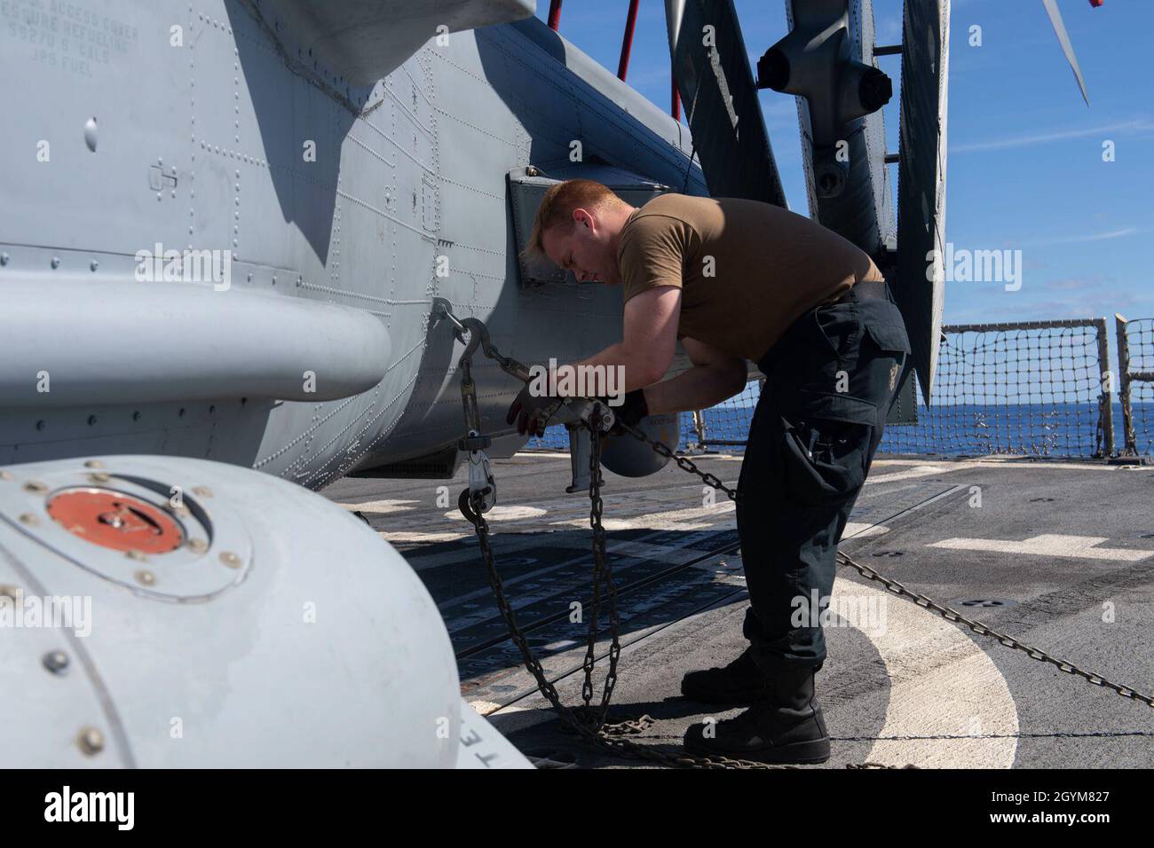 PACIFIC OCEAN (Jan. 28, 2020) Aviation Electrician’s Mate Airman Andrew Wilhite, right, from Menomonie, Wis., secures an MH-60R Sea Hawk, assigned to the “Scorpions” of Helicopter Maritime Strike Squadron (HSM) 49, to the flight deck of the Arleigh Burke-class guided-missile destroyer USS Rafael Peralta (DDG 115) Jan. 28, 2020. Rafael Peralta, part of the Theodore Roosevelt Carrier Strike Group, is on a scheduled deployment to the Indo-Pacific. (U.S. Navy photo by Mass Communication Specialist 2nd Class Jason Isaacs) Stock Photo