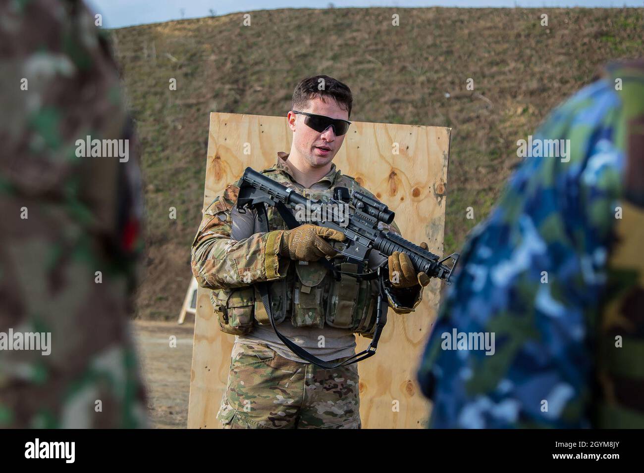 Members of the Romanian armed forces conduct marksmanship training with