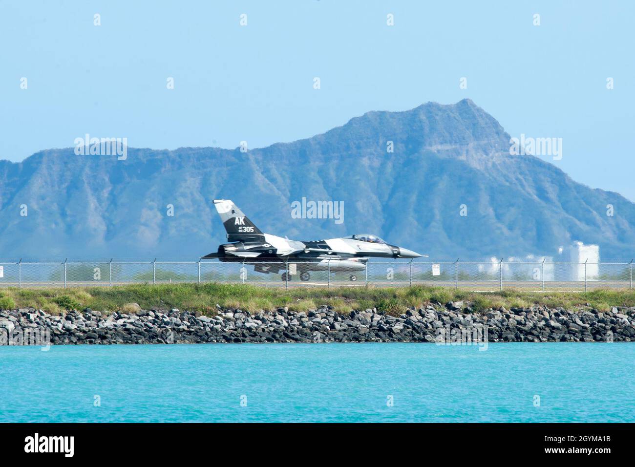An F-16 Fighting Falcon from the 18th Aggressor Squadron taxis down the Honolulu Airport Runway Jan. 29, 2020. The aircraft practiced combat tactics alongside the world’s most advanced fifth-generation airframes, the F-22 Raptor and F-35A Lightning II. The F-16 is assigned to the 18th Aggressor Squadron in Eielson Air Force Base, Alaska, and its mission is to prepare pilots for victory by simulating combat tactics which are likely to be faced in the event of an air-to-air battle.  (U.S. Air Force photo by Senior Airman John Linzmeier) Stock Photo