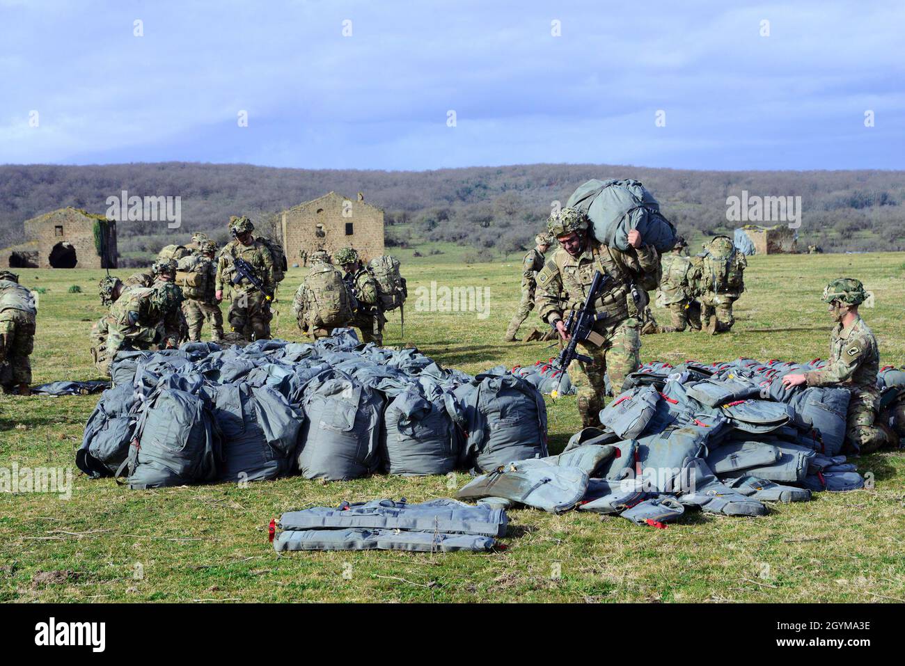 U.S. Army paratroopers from HHC, 2nd Battalion, 503rd  Infantry Regiment, 173rd Airborne Brigade carry their parachutes to the check-in point during Exercise Rock Topside 20, Monte Romano, Italy, Jan. 29, 2020. Rock Topside is a joint forced entry exercise to train the battalion’s ability to conduct airborne contingency response force operations. This training stresses the interoperability of both the paratroopers of the 2nd Battalion, 503rd Infantry Regiment and Italian paratroopers of Reggimento Savoia Cavalleria 3. (U.S Army photo by Elena Baladelli) Stock Photo