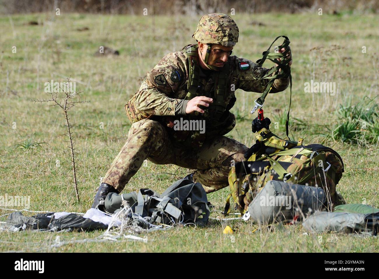 A Italian Army paratrooper from Reggimento Savoia Cavalleria 3 recovers his parachute after the airborne operation during Exercise Rock Topside 20, Monte Romano, Italy, Jan. 29, 2020.  Rock Topside 20 is a join forced entry exercise to train the battalions ability to conduct airborne contingency response force operations. This training stresses the interoperability of both the paratroopers of the 2nd Battalion, 503rd Infantry Regiment and Italian paratroopers Reggimento Savoia Cavalleria 3. (U.S Army photo by Elena Baladelli) Stock Photo