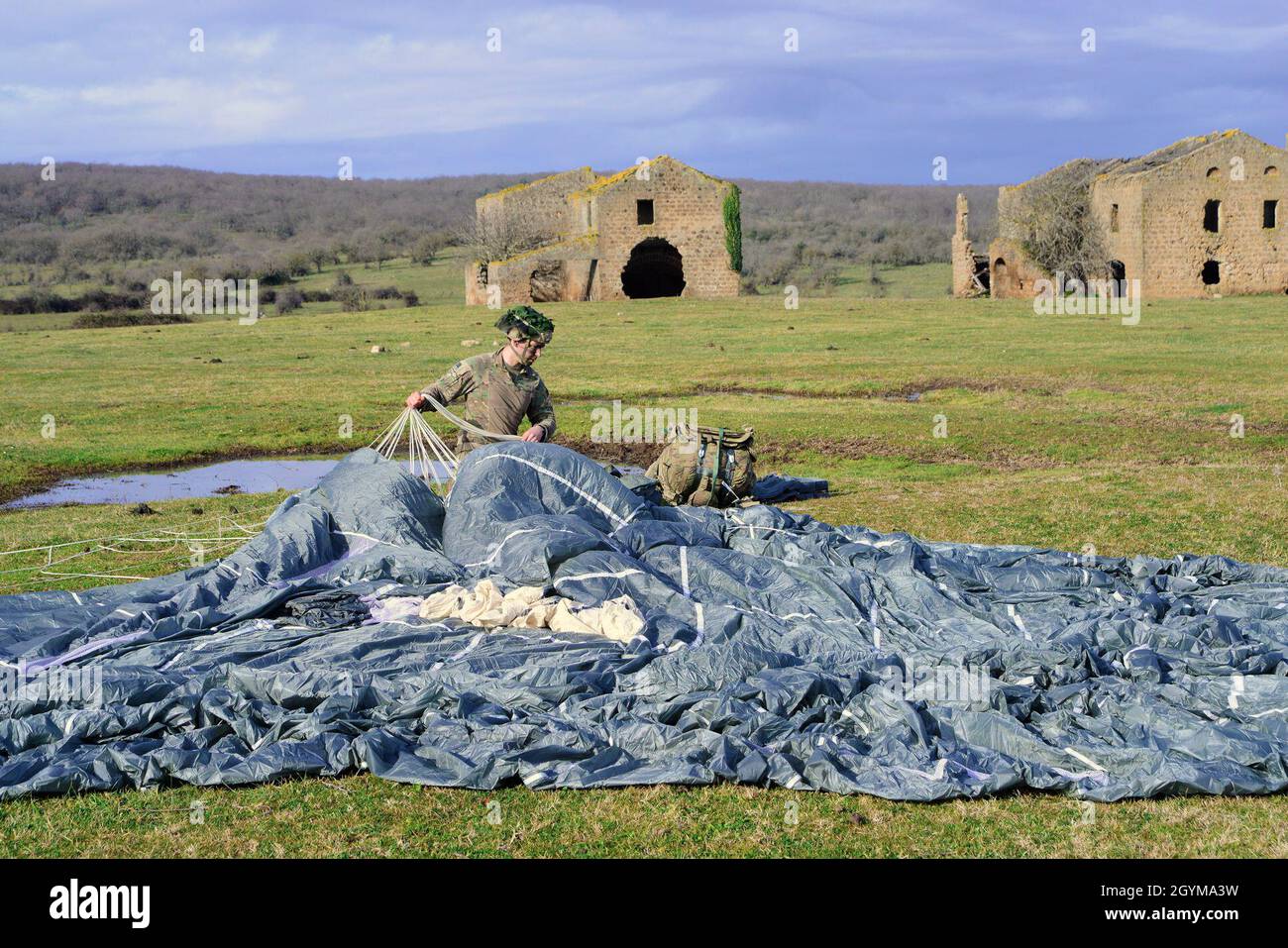 A U.S. Army paratrooper from HHC, 2nd Battalion, 503rd  Infantry Regiment, 173rd Airborne Brigade recovers his parachute after the airborne operation  during Exercise Rock Topside 20, Monte Romano, Italy, Jan. 29, 2020. Rock Topside is a joint forced entry exercise to train the battalion’s ability to conduct airborne contingency response force operations. This training stresses the interoperability of both the paratroopers of the 2nd Battalion, 503rd Infantry Regiment and Italian paratroopers of Reggimento Savoia Cavalleria 3. (U.S Army photo by Elena Baladelli) Stock Photo