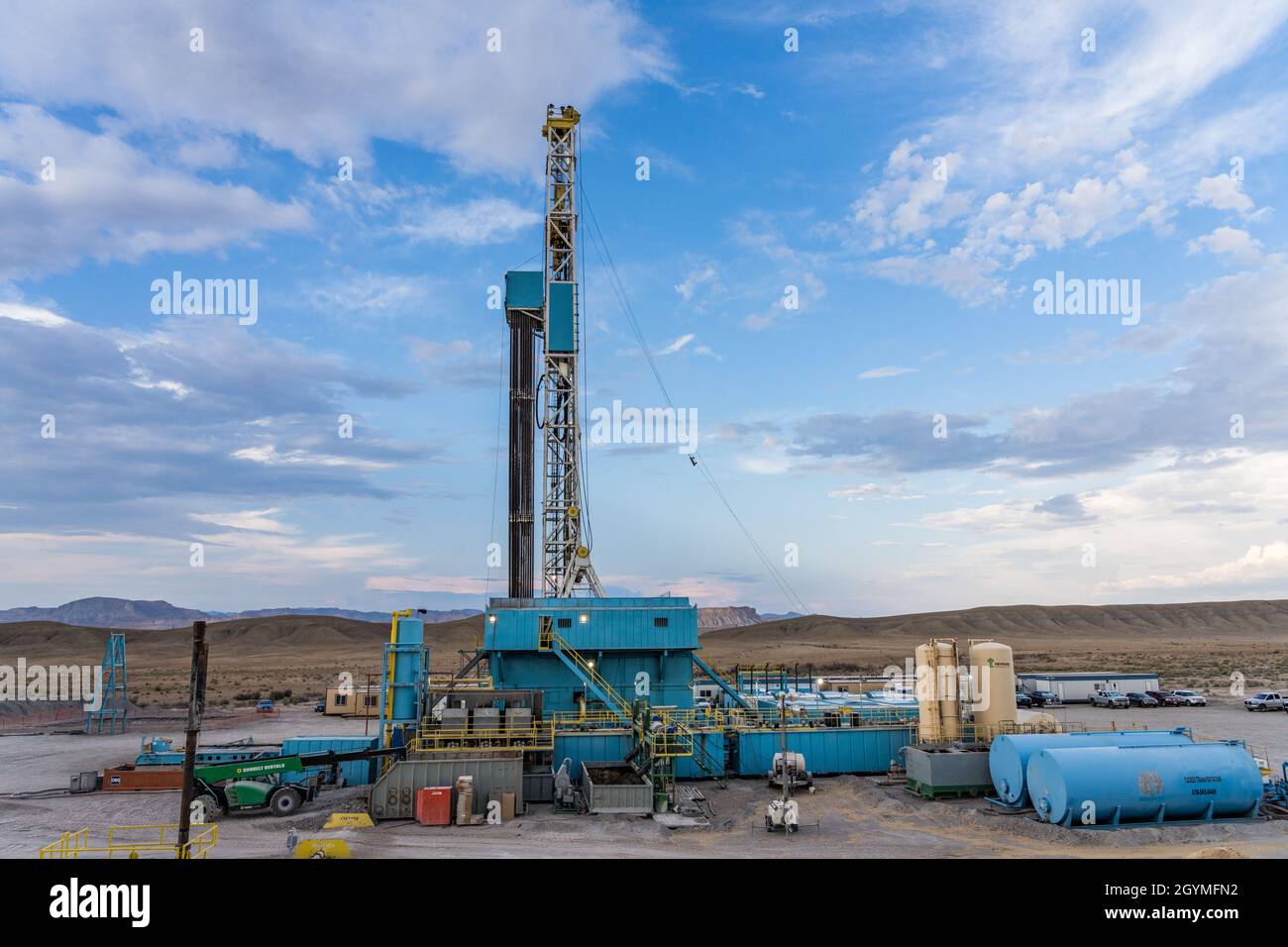 A 3000 hp top drive drilling rig drilling for oil in the Green River Desert in central Utah.  In the distance are the Book Cliffs. Stock Photo