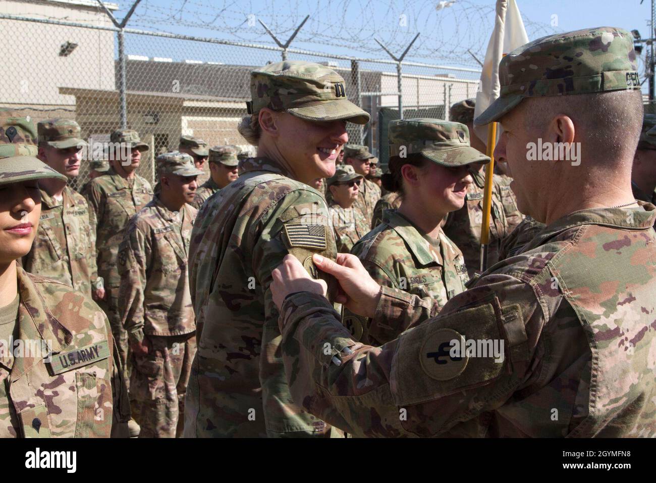 Brig. Gen. Howard Geck, commanding general, 103rd Expeditionary Sustainment Command (ESC), presents Capt. Shelby Peters, 103rd ESC, with a combat patch during an award, patching, and promotion ceremony at Camp Arifjan, Kuwait, Feb. 2, 2020. (U.S. Army Reserve photo by Spc. Dakota Vanidestine) Stock Photo