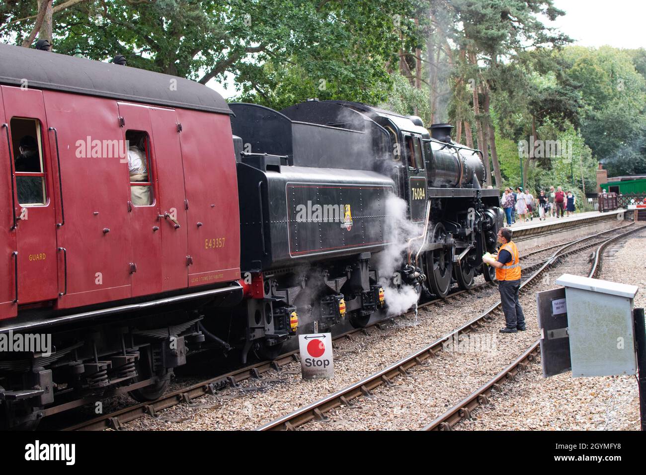 Sheringham, Norfolk, UK - SEPTEMBER 14 2019: Black BR Standard 4 76084 steam train carrying red carriages stands by the platform Stock Photo