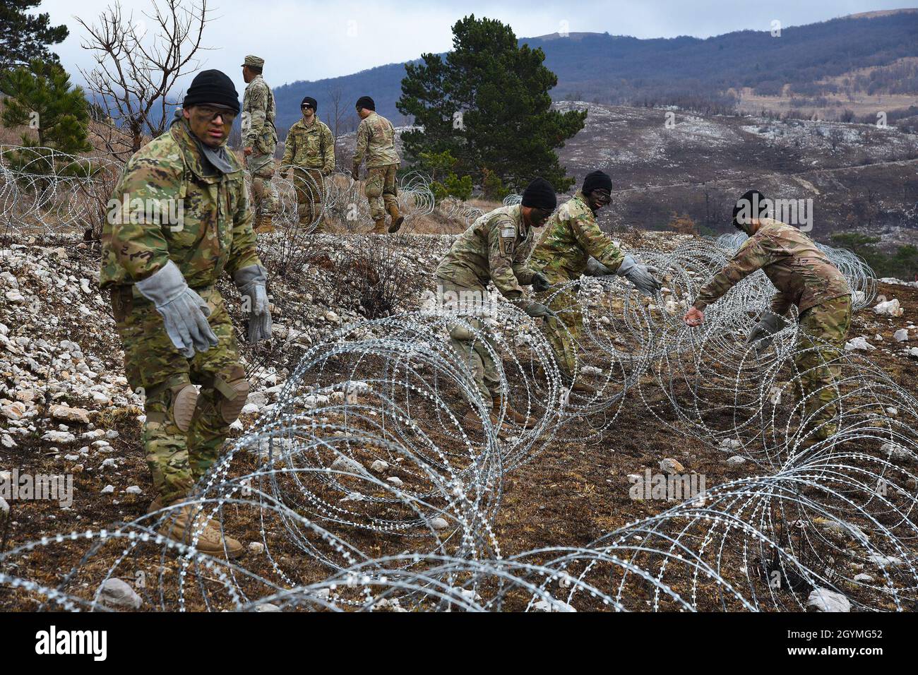 U.S. Army Paratroopers assigned to the 173rd Brigade Support Battalion, 173rd Airborne Brigade, lay out barbed wire during Exercise Lipizzaner VI at Pocek Range in Postonja, Slovenia, Feb. 02, 2020. Lipizzaner is a combined squad-level training exercise in preparation for platoon evaluation, and to validate battalion-level deployment procedures. The 173rd Airborne Brigade is the U.S. Army Contingency Response Force in Europe, capable of projecting ready forces anywhere in the U.S. European, Africa or Central Commands' areas of responsibility. (U.S. Army photo by Paolo Bovo) Stock Photo