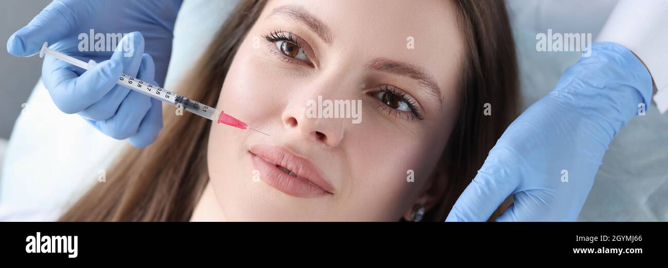 Doctor cosmetologist gives woman an injection to smooth out wrinkles Stock Photo