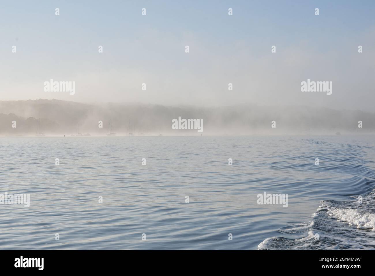 Early summer morning fog scene in Port Jefferson Harbor, Long Island, NY. Copy space. Stock Photo