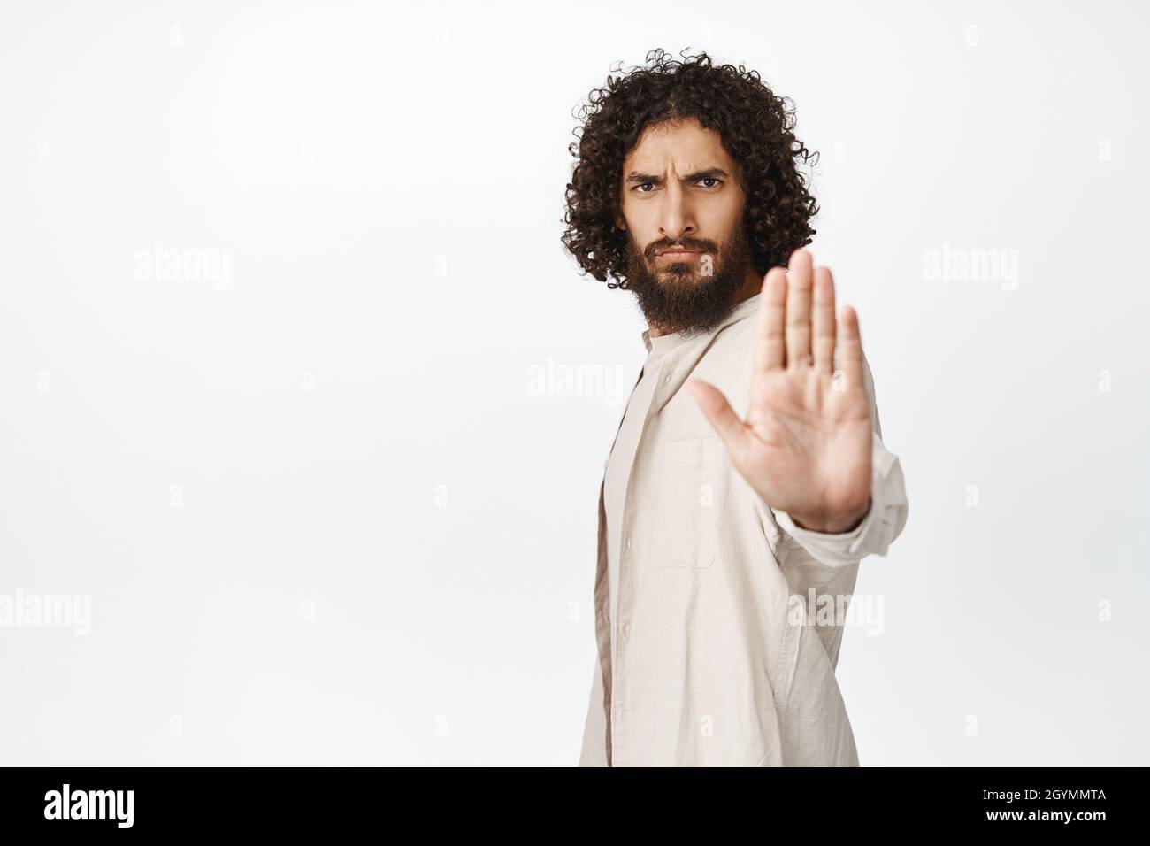 Serious and confident middleeastern man extend arm, stop sign, say no