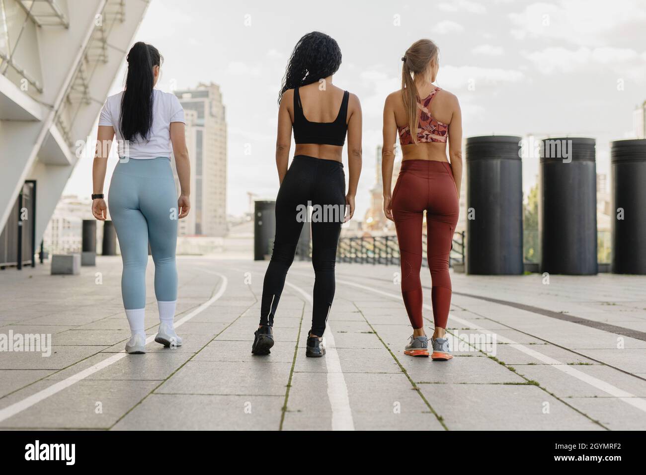 Three beautiful fitness women in sportwear outdoors. Stock Photo