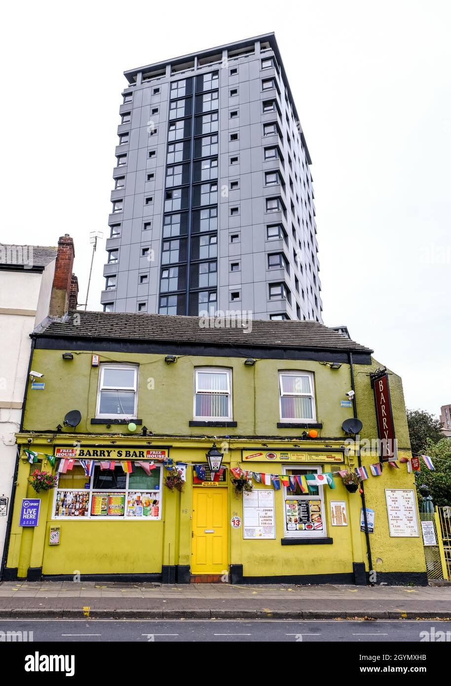 ABarry's Bar, a pub in a central area of Sheffield with a block of high rise flats towering above. Stock Photo