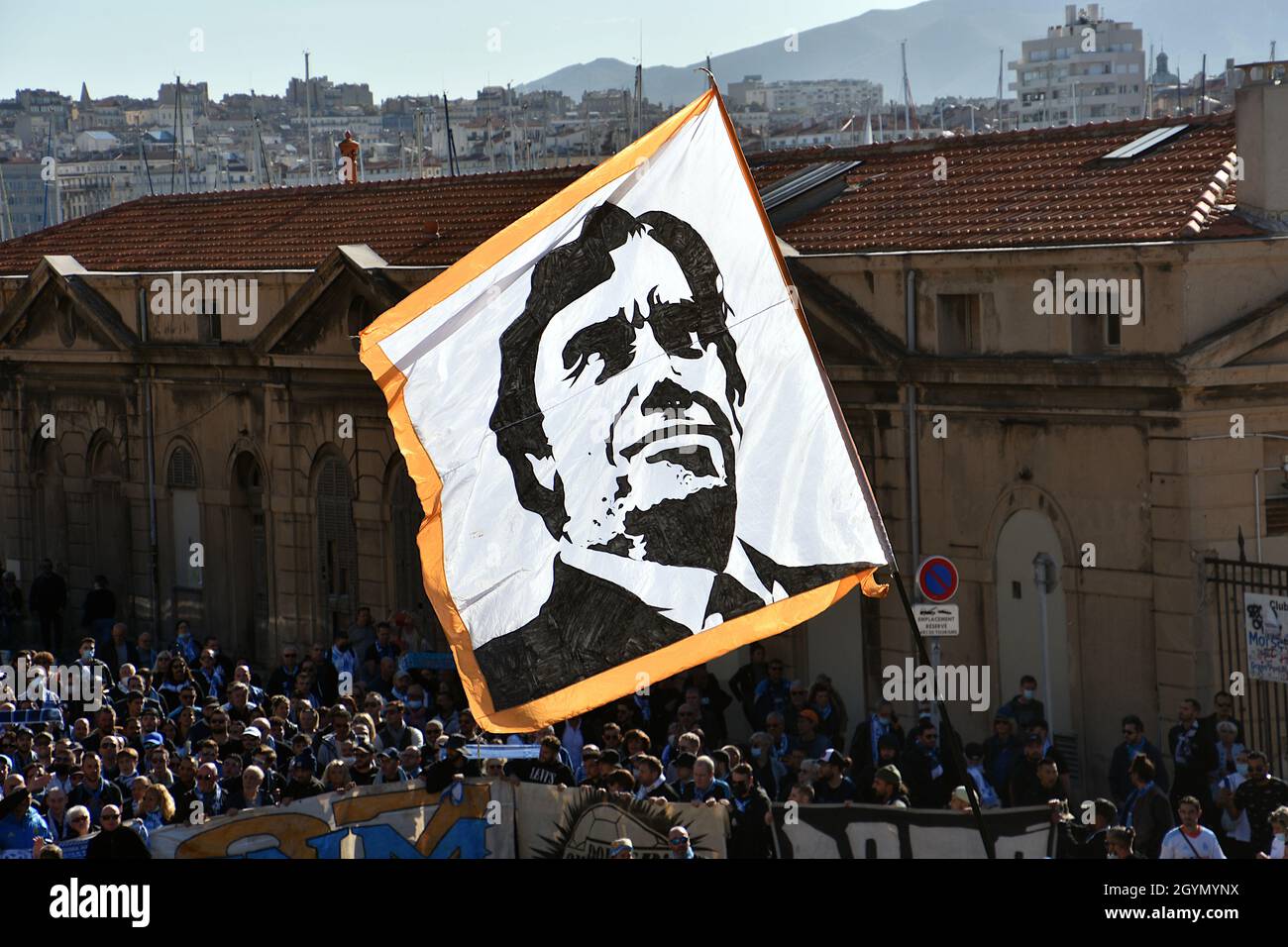 Marseille, France. 08th Oct, 2021. A man waves a flag depicting the portrait of Bernard Tapie during the funeral.The supporters of the Olympique de Marseille (OM) pay a last tribute to Bernard Tapie, business magnate and former owner of the famous football club, by accompanying him for his funeral from the Vieux-Port to the Major Cathedral of Marseille. Bernard Tapie died in Paris on October 3, 2021 at the age of 78, after a four-year battle with stomach cancer. Credit: SOPA Images Limited/Alamy Live News Stock Photo