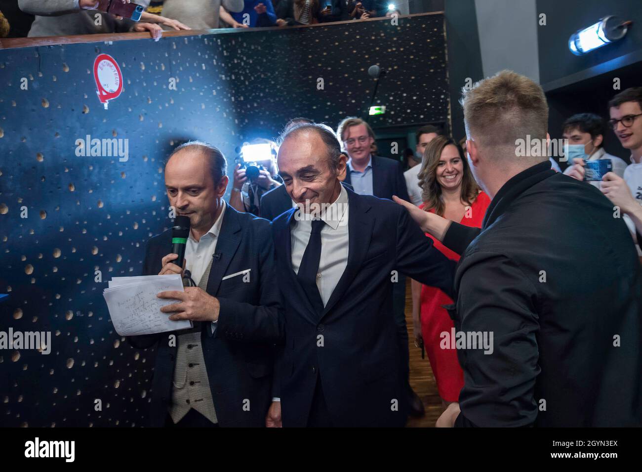 Olivier Ubeda (Left) is seen accompanying Eric Zemmour followed by his team (Antoine Diers) and Sarah Knafo (red dress) as he enters the room among his supporters. Eric Zemmour behaved like a candidate in an electoral campaign, even if he has not yet officially declared his entry in the race for the French presidential elections of 2022. Around him are now appearing new collaborators specialized in electoral campaigning and a merchandising marked 'Zemmour2022'. Since the recent poll that placed him on par with Marine Le Pen for the second round against Emmanuel Macron, his attitude and organiz Stock Photo