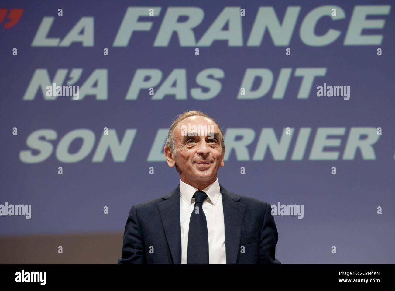 Lille, France. 2nd Oct, 2021. Eric Zemmour seen before his speech with the title of his latest book displayed on a screen in the background.Eric Zemmour behaved like a candidate in an electoral campaign, even if he has not yet officially declared his entry in the race for the French presidential elections of 2022. Around him are now appearing new collaborators specialized in electoral campaigning and a merchandising marked ''Zemmour2022''. Since the recent poll that placed him on par with Marine Le Pen for the second round against Emmanuel Macron, his attitude and organization leave little Stock Photo