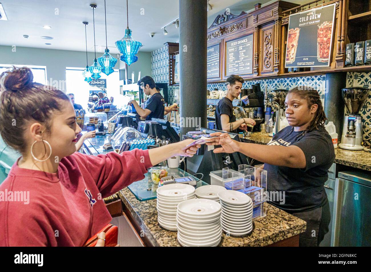 London England,UK,Trafalgar Square,Cafe Nero coffee shop inside interior counter,cashier barista Black woman female customer paying getting change Stock Photo